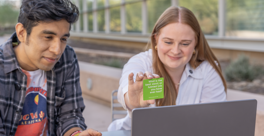 Student showing card to laptop camera